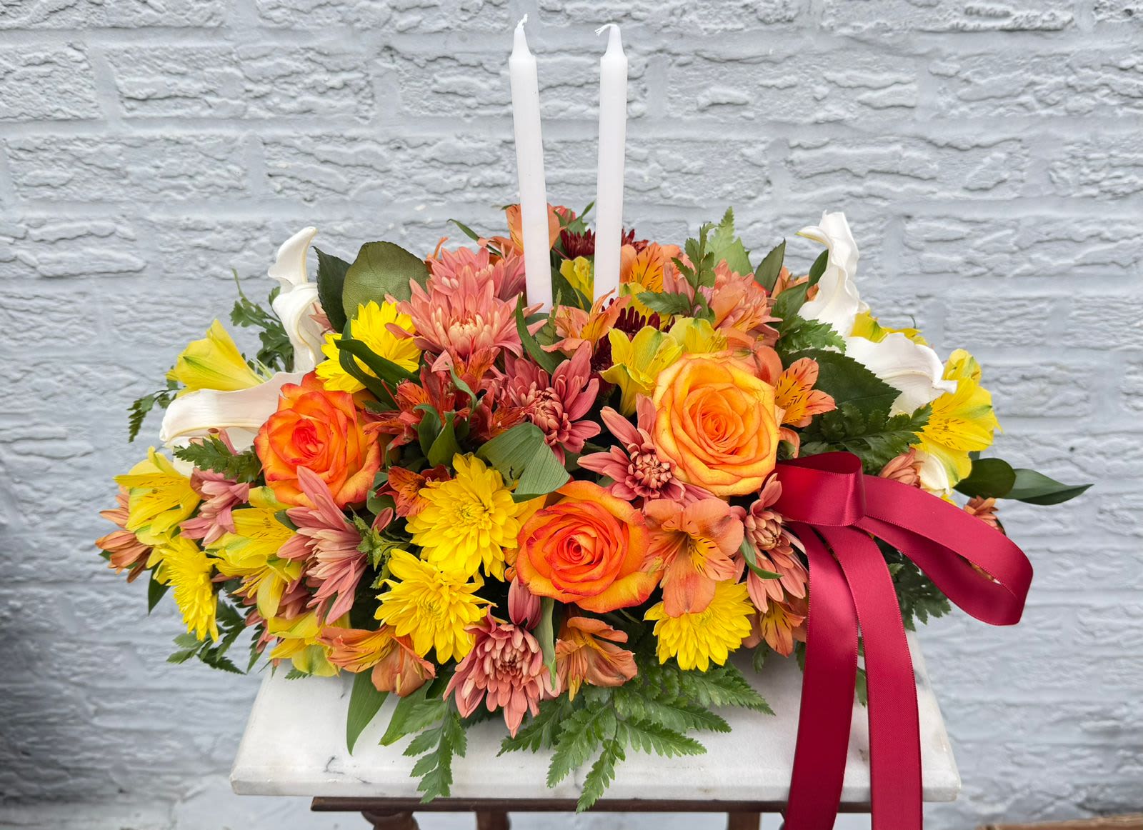 “Happy Thanksgiving” centerpiece - “This stunning centerpiece is handcrafted with fresh flowers and accented with an elegant ribbon and candles. A perfect way to celebrate Thanksgiving and share warm wishes with your loved ones.”