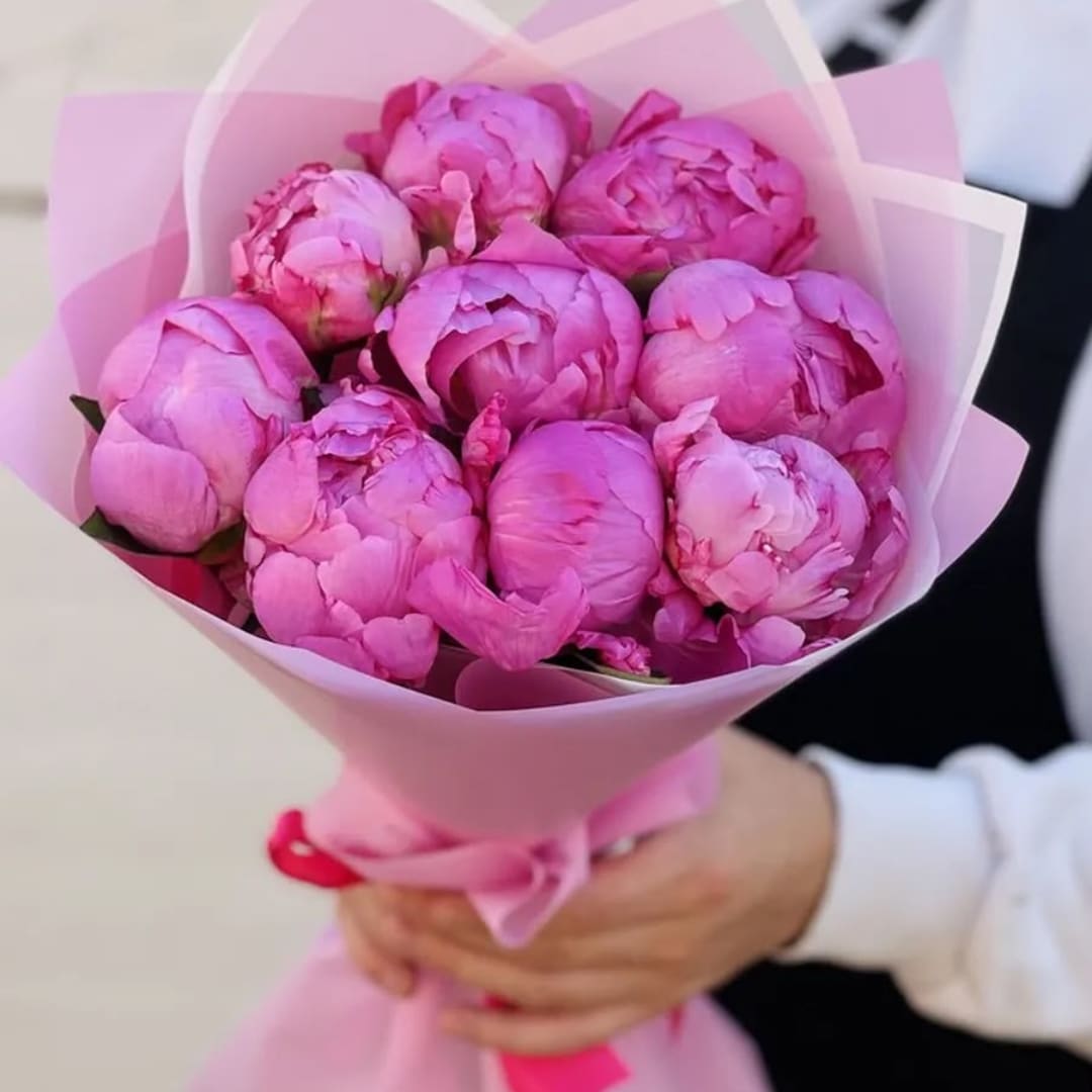 Pink peony bouquet wrapped in pale pink paper and ribbon