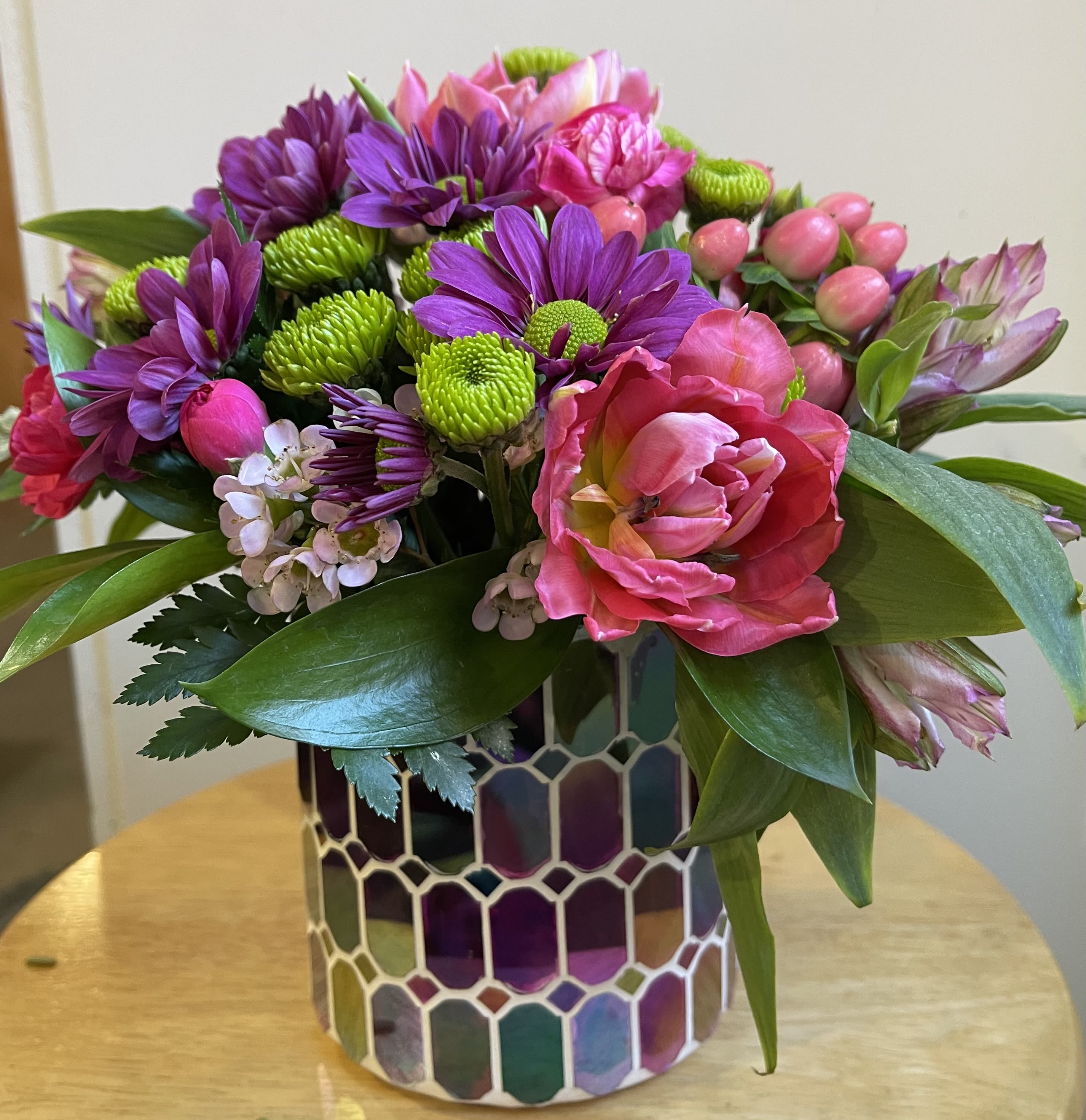 Pink and purple mixed bouquet in a mosaic glass vase