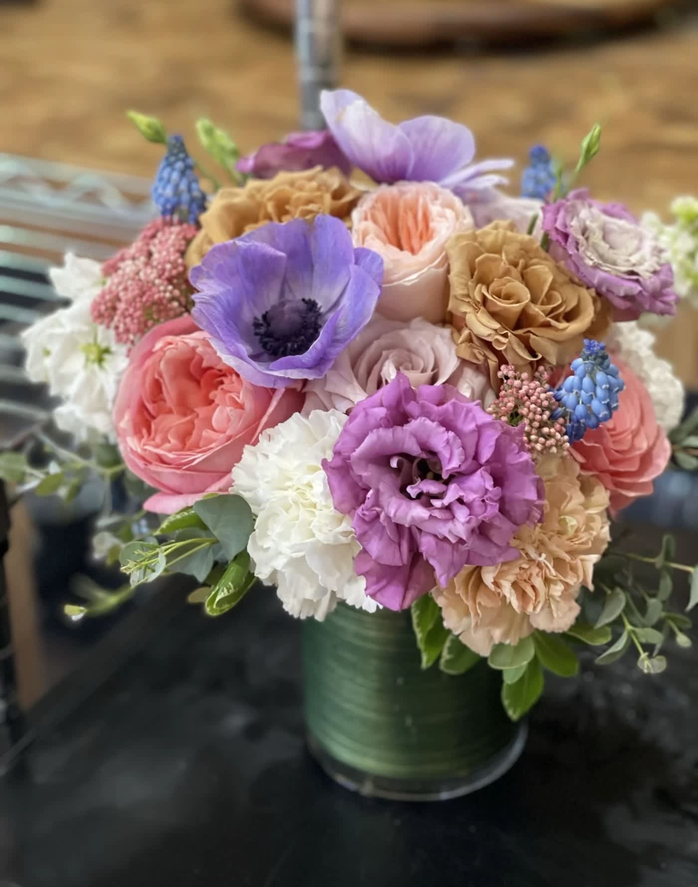 Mixed bouquet of pastel flowers in a green vase