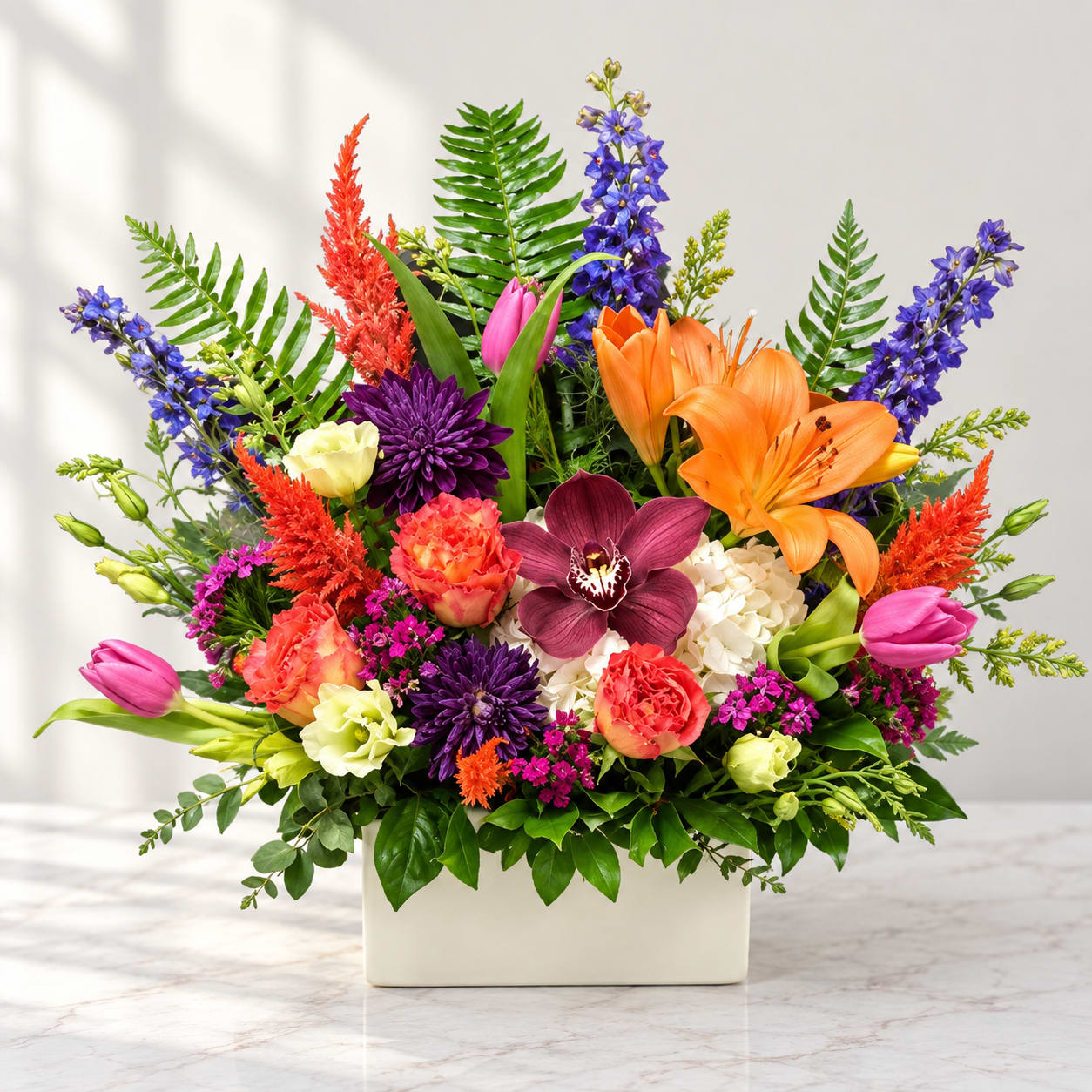 Colorful mixed flower arrangement in a white rectangular vase