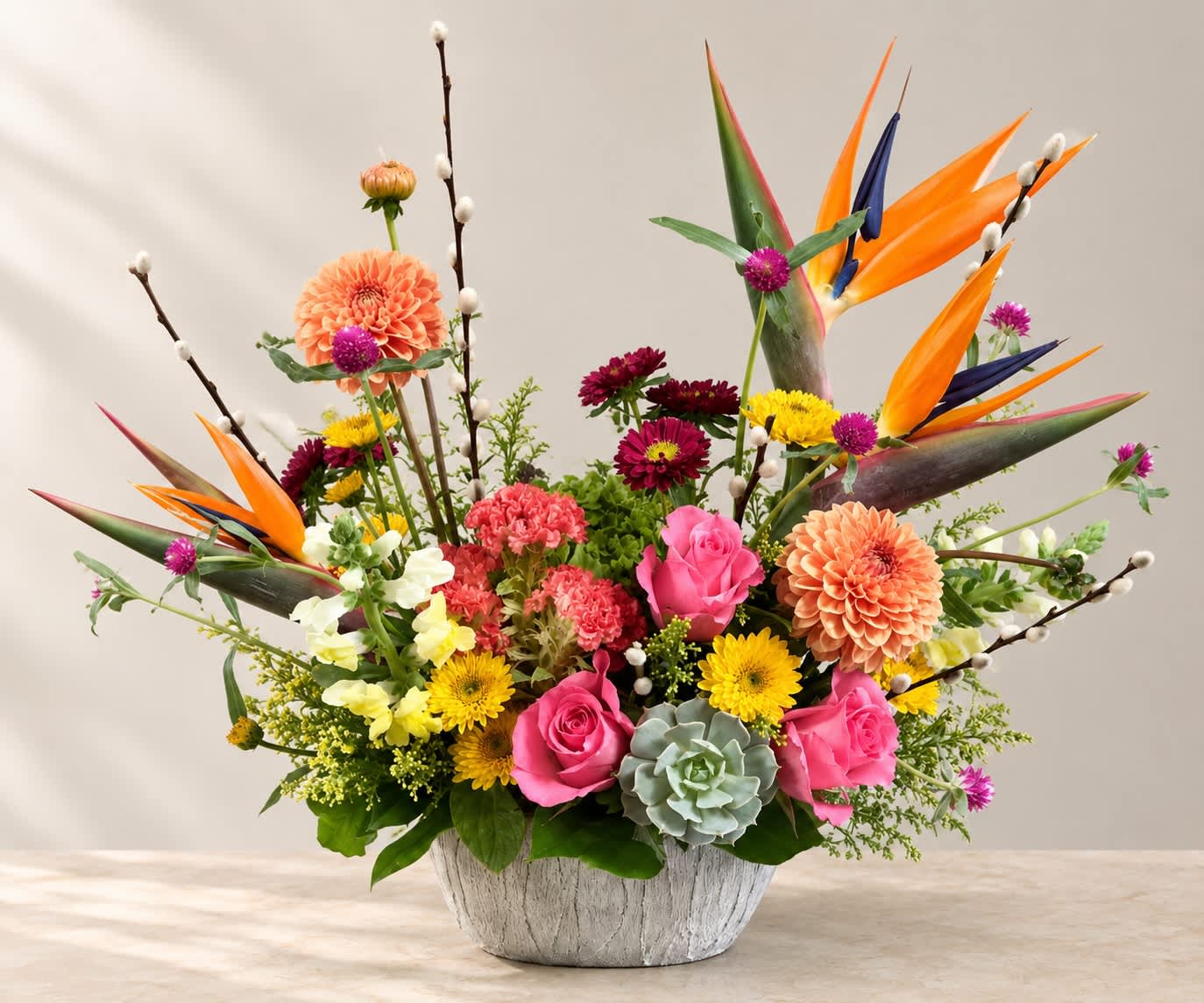 Colorful mixed flower arrangement in a white textured bowl vase