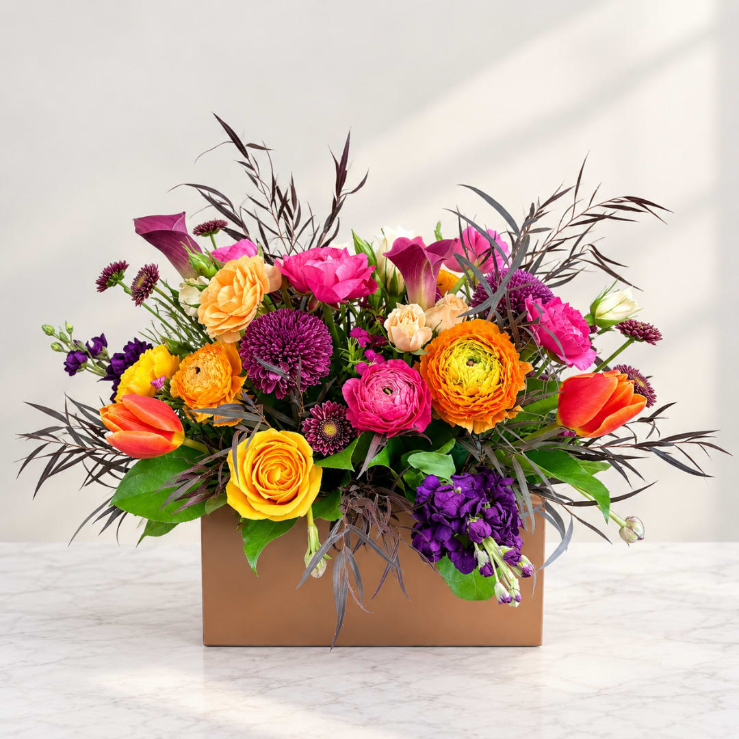 Colorful mixed bouquet in a brown box with tulips and roses