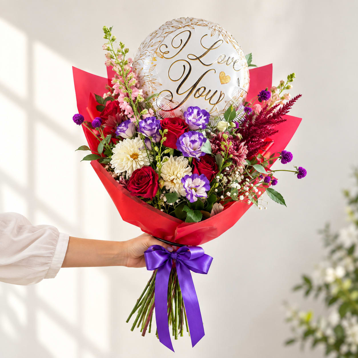 Handheld bouquet of mixed flowers with a "I Love You" balloon