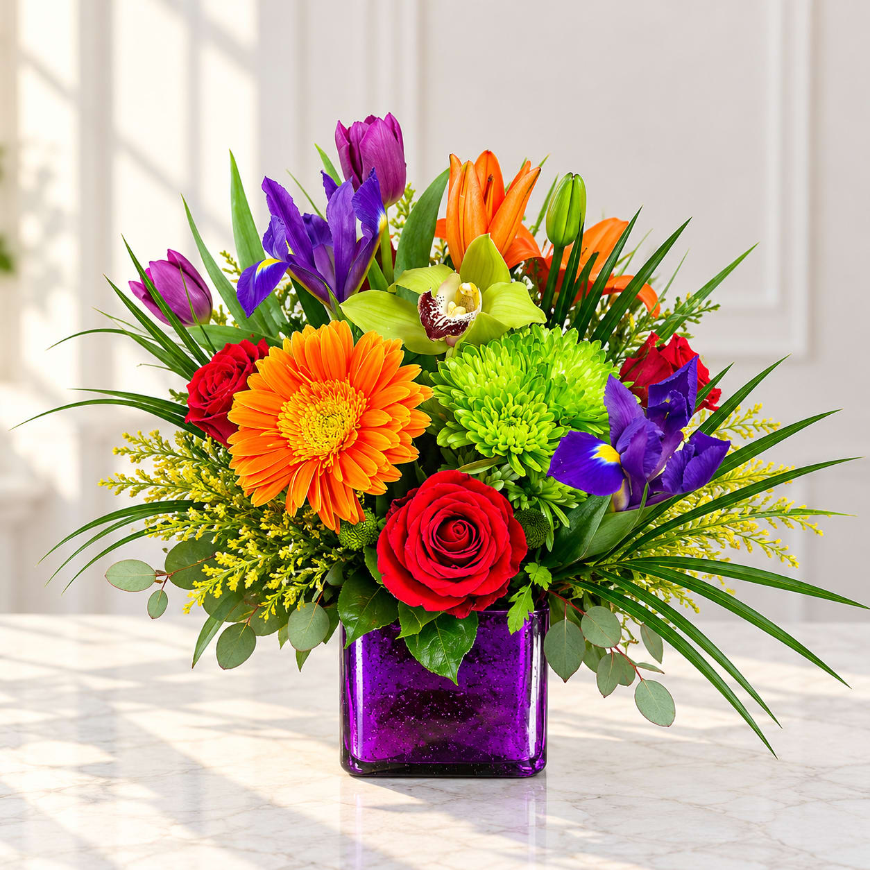 Colorful bouquet in a purple glass vase with roses, gerbera daisies, lilies, and irises