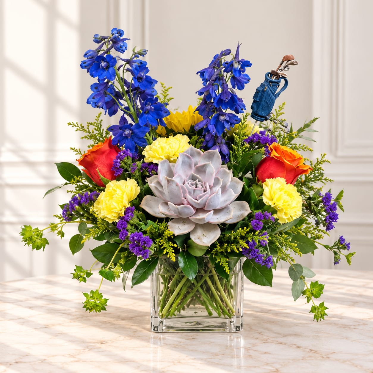 Colorful bouquet in a clear square vase with a golf-themed pick