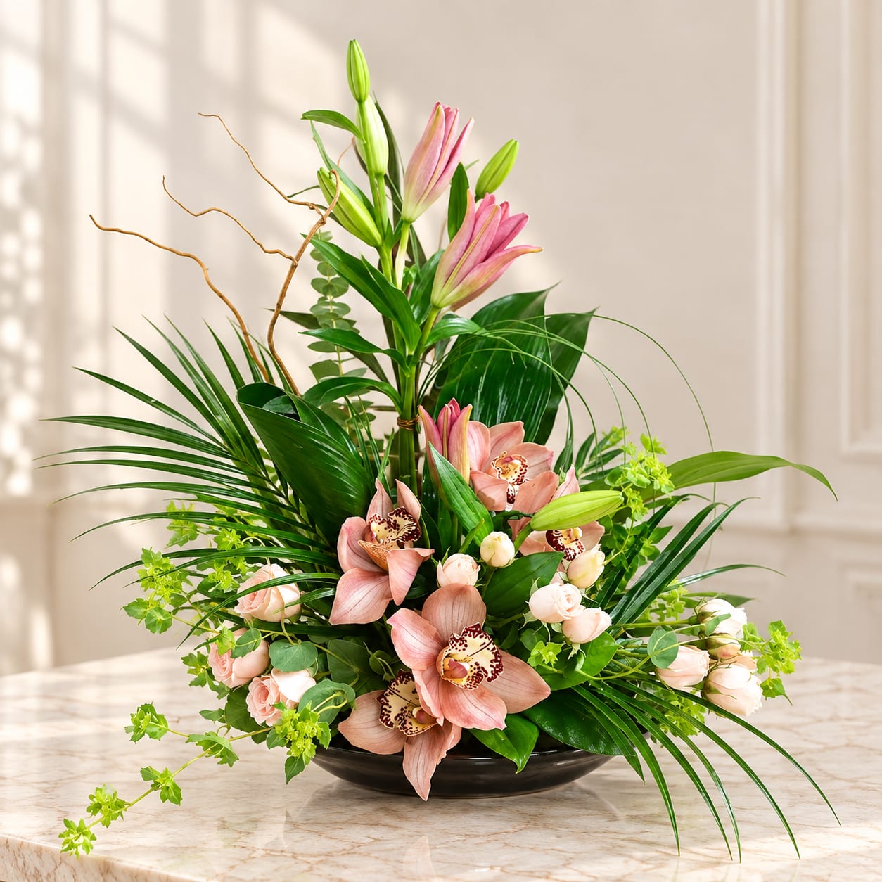 Pink orchids and roses arranged in a black bowl vase