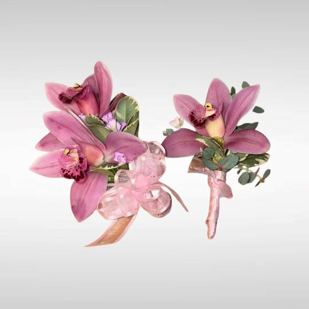 Two pink orchid boutonnieres with ribbon accents