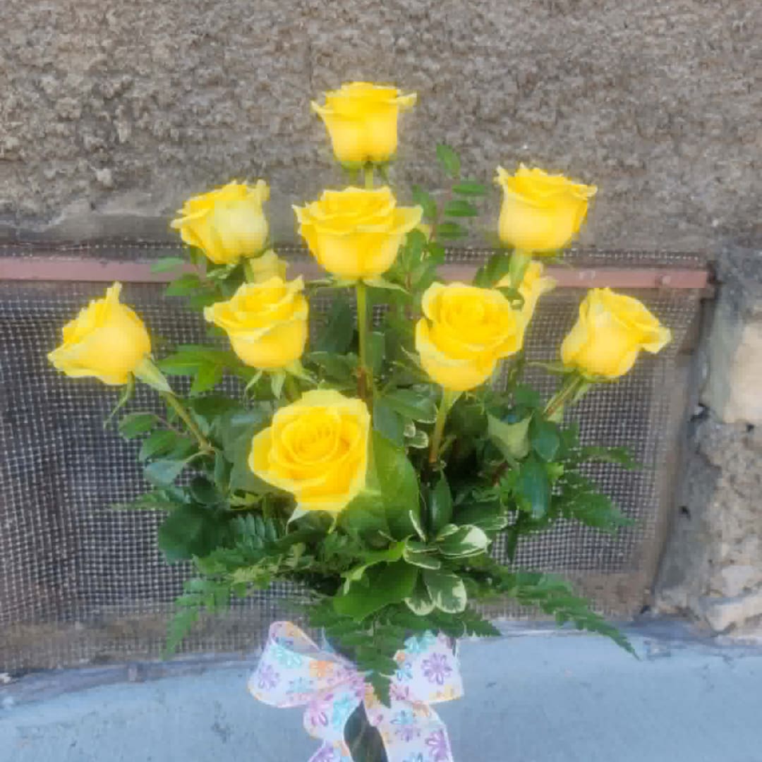 Yellow roses in a vase with a pastel floral ribbon