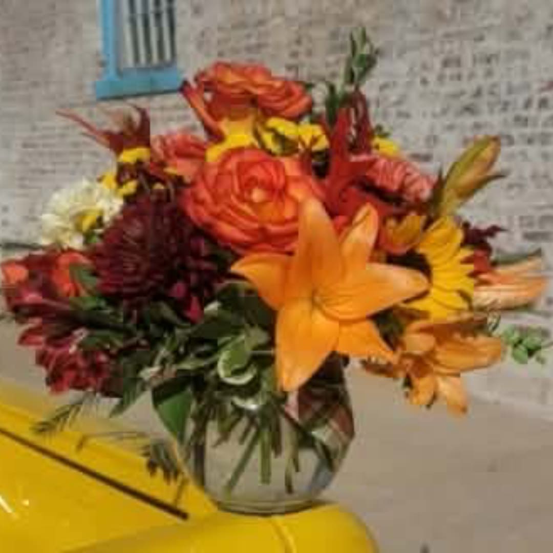 Orange and yellow mixed flower bouquet in a glass vase