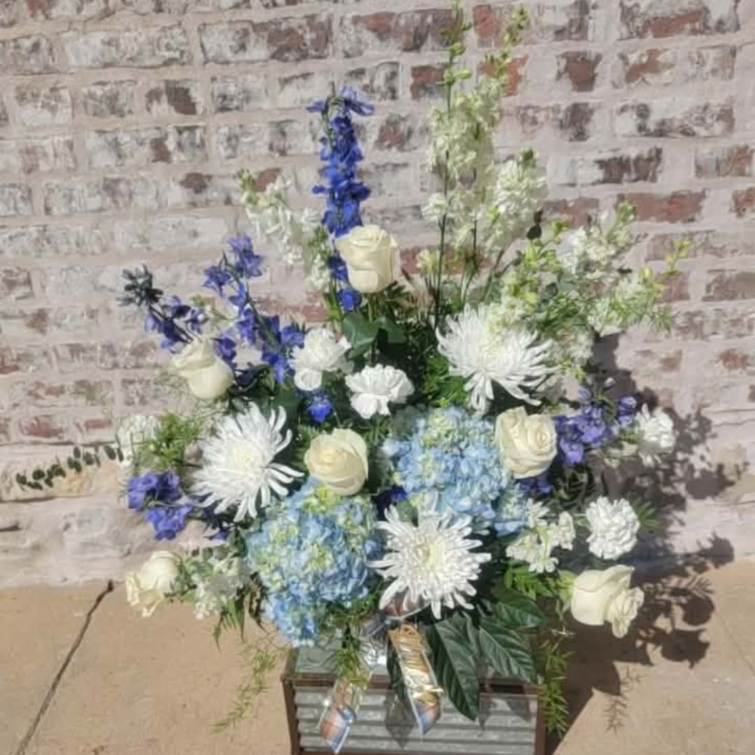 Blue and white floral arrangement in a rectangular container