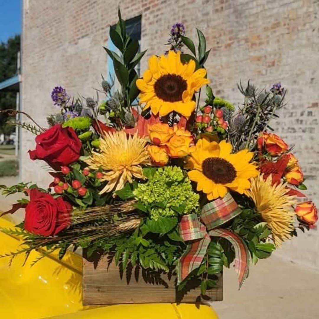 Bouquet with sunflowers and red roses in a wooden box