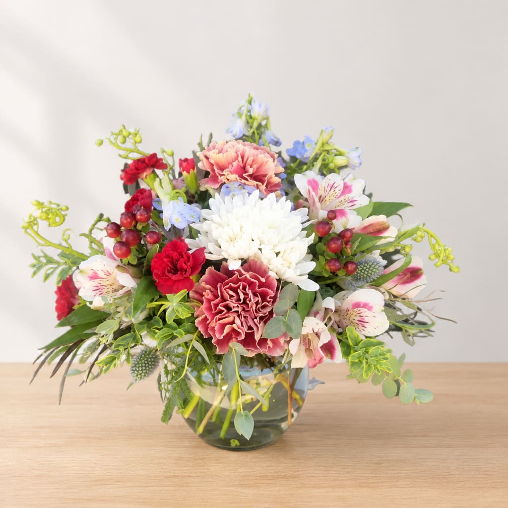Mixed bouquet in a glass vase with white, pink, and red flowers