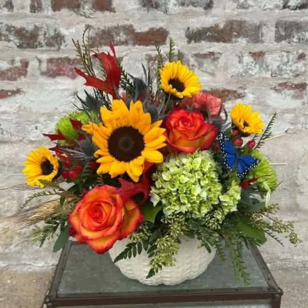 Bouquet of sunflowers, roses, and green hydrangea in a white vase