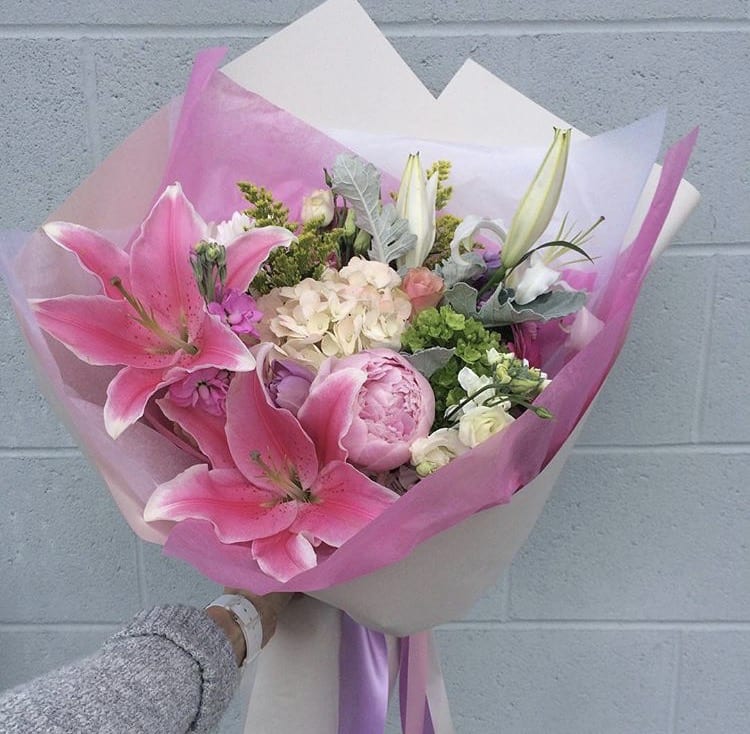 Pink lily and peony bouquet wrapped in pink and white paper
