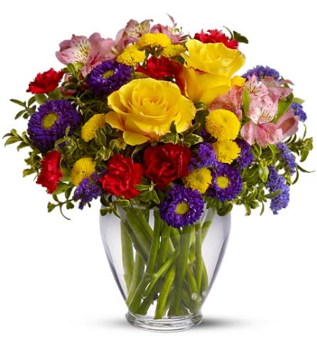 Mixed bouquet of yellow roses, red carnations, and purple daisies in a glass vase