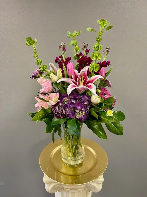 Mixed bouquet in a clear glass vase with pink, purple, and white blooms