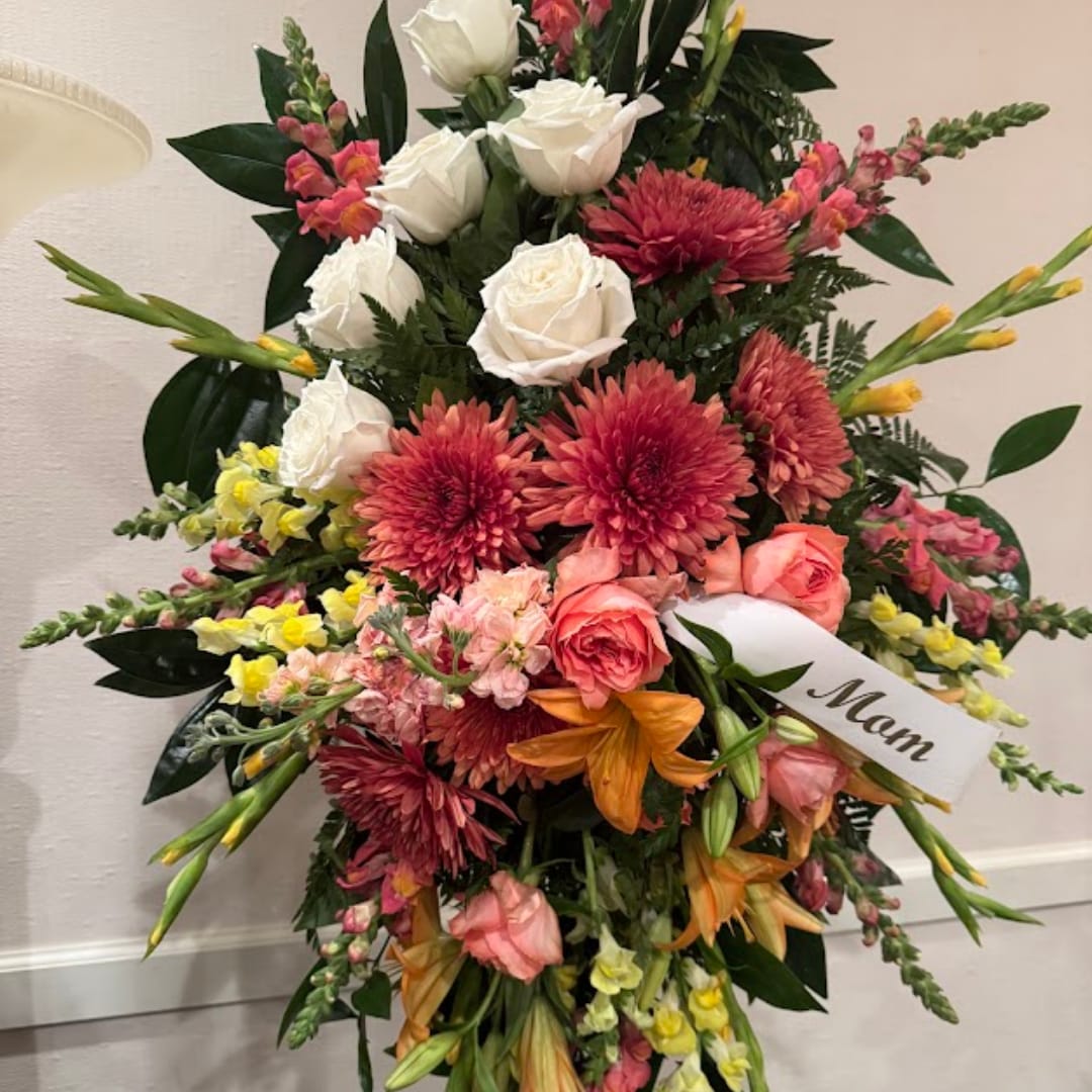 Tall mixed bouquet with white roses, pink blooms, and orange lilies