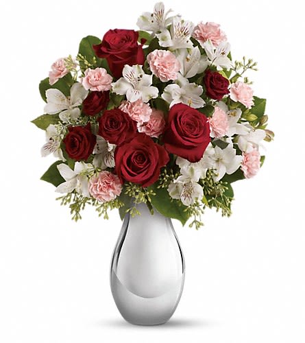 Red roses and white flowers arranged in a silver vase