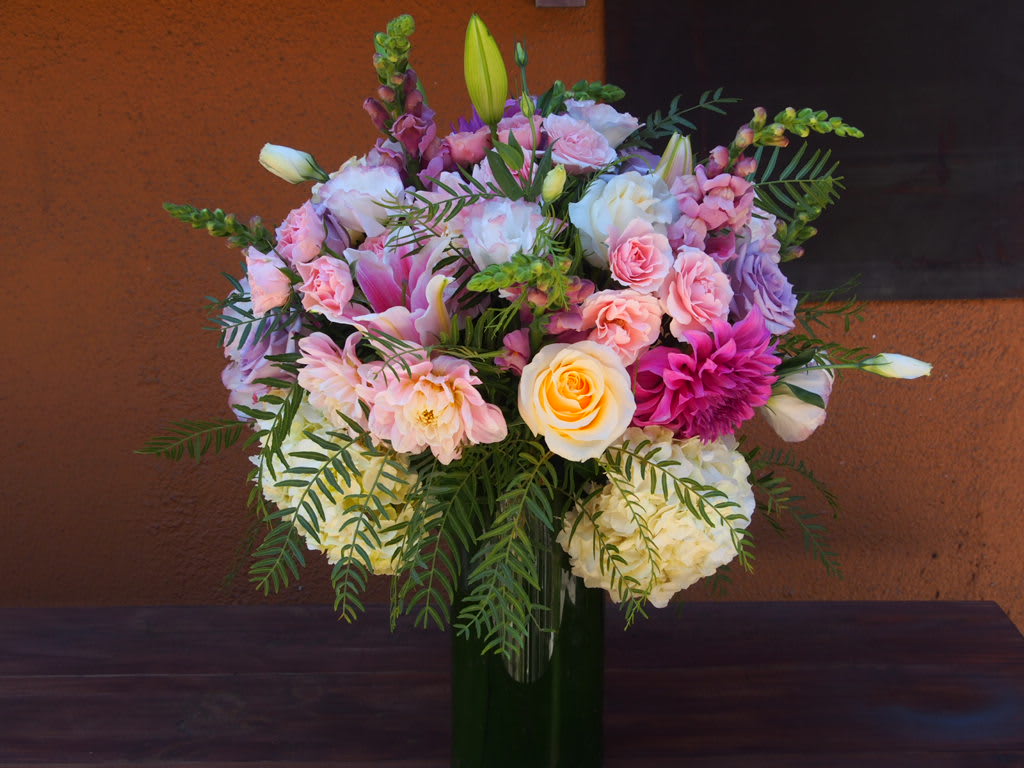 Mixed pink and white flower bouquet in a tall glass vase
