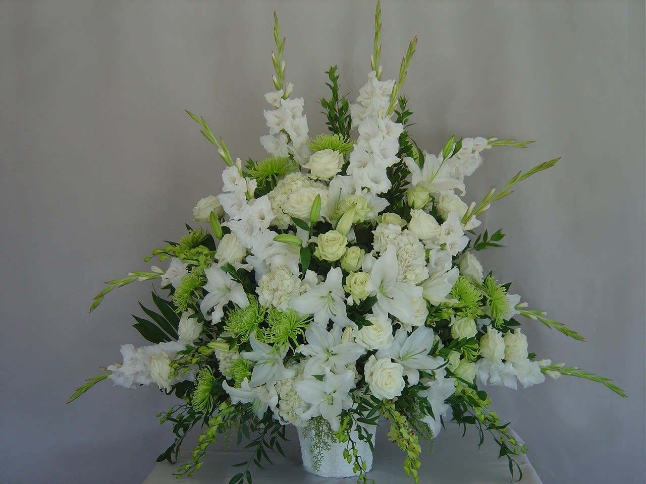 White floral arrangement with lilies and roses in a vase