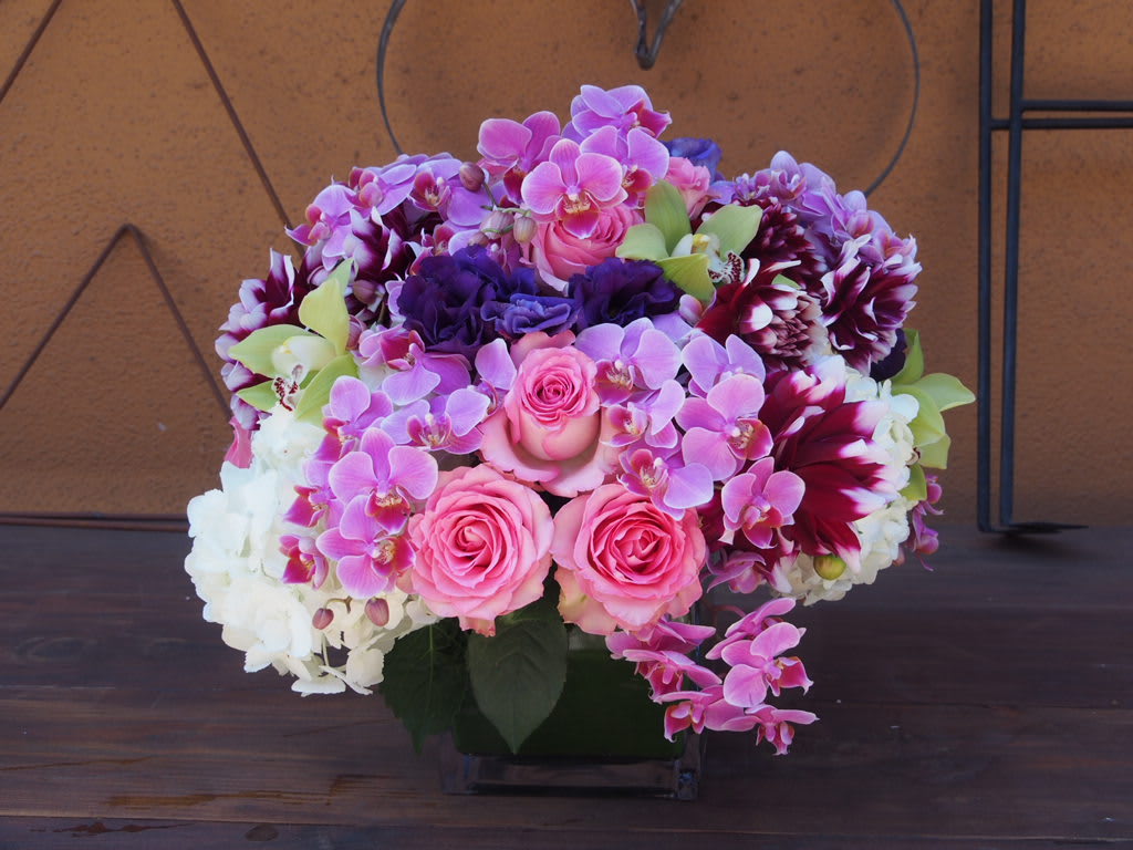 Sweetheart  - 6" sqare vase with lush arrangement in the pink/purple colors. Arrangement  to include orchids (orchid type and color may changed).