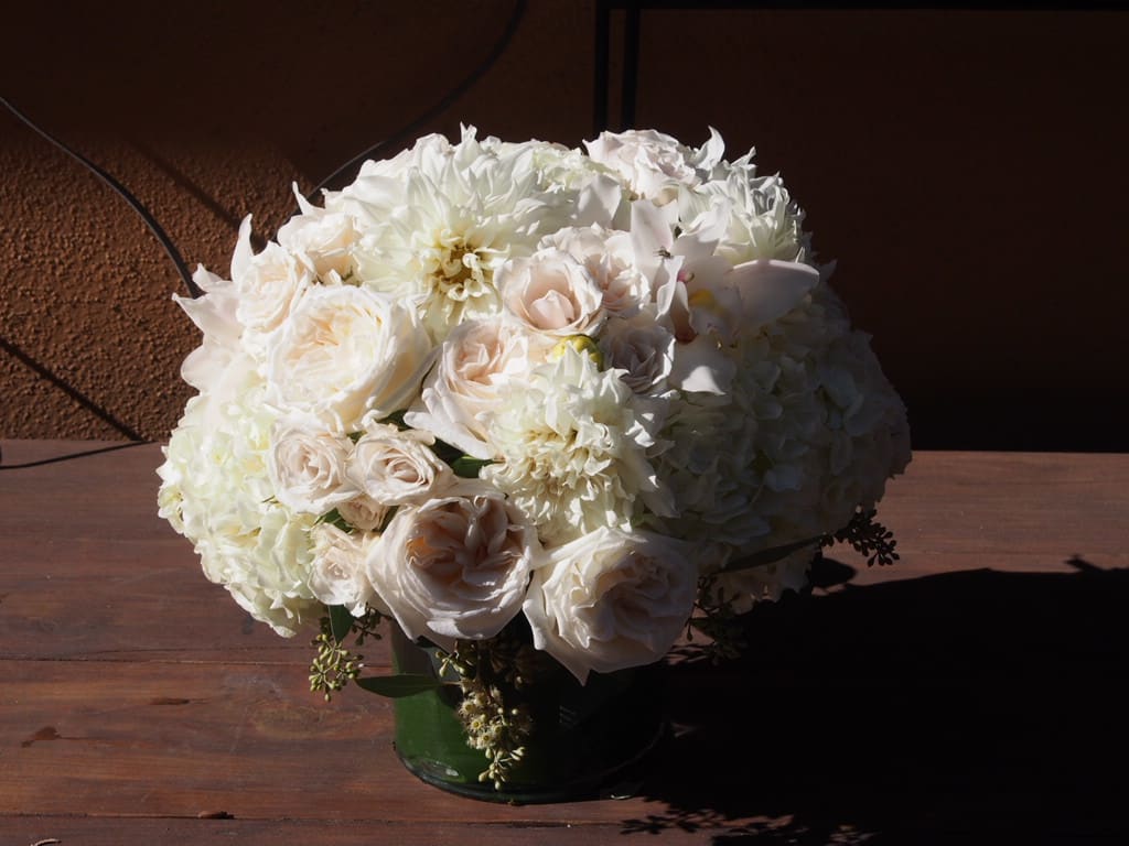 White roses and hydrangeas arranged in a green vase