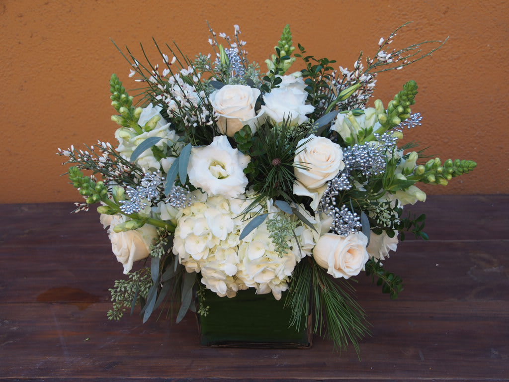 White roses and hydrangeas in a square vase with silver accents