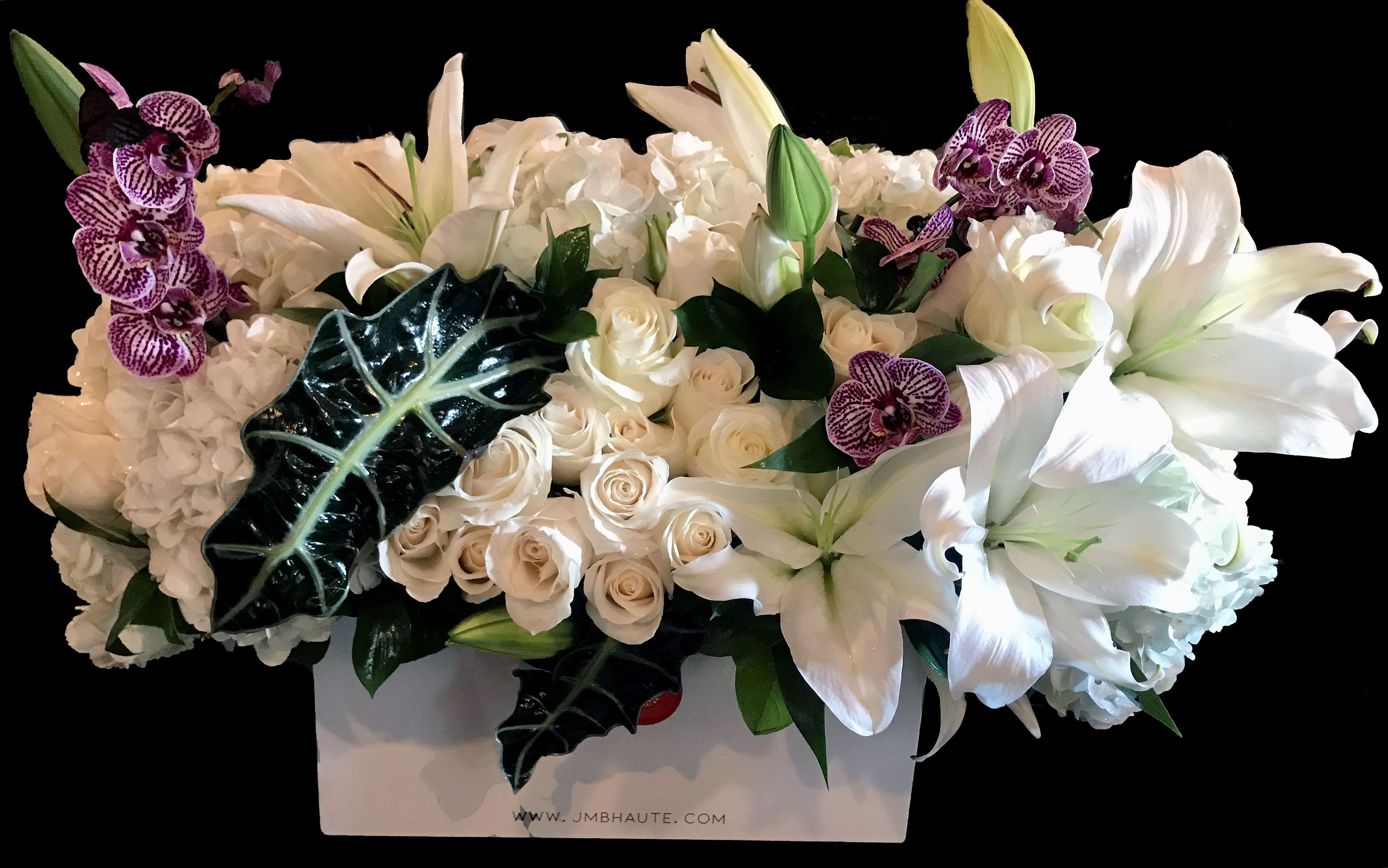 White lilies, roses, hydrangeas, and purple orchids in a white box