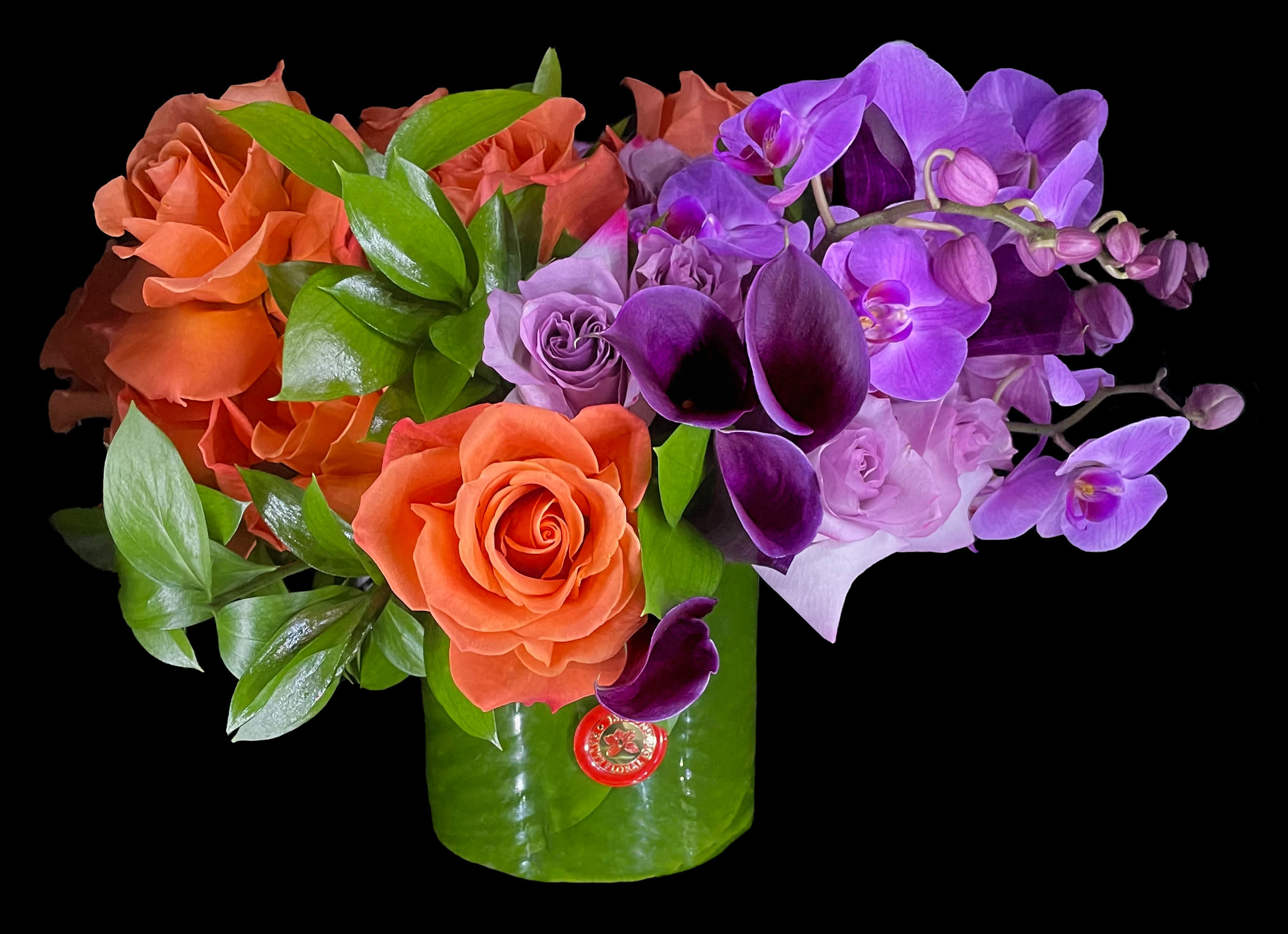 Orange roses and purple orchids in a green vase