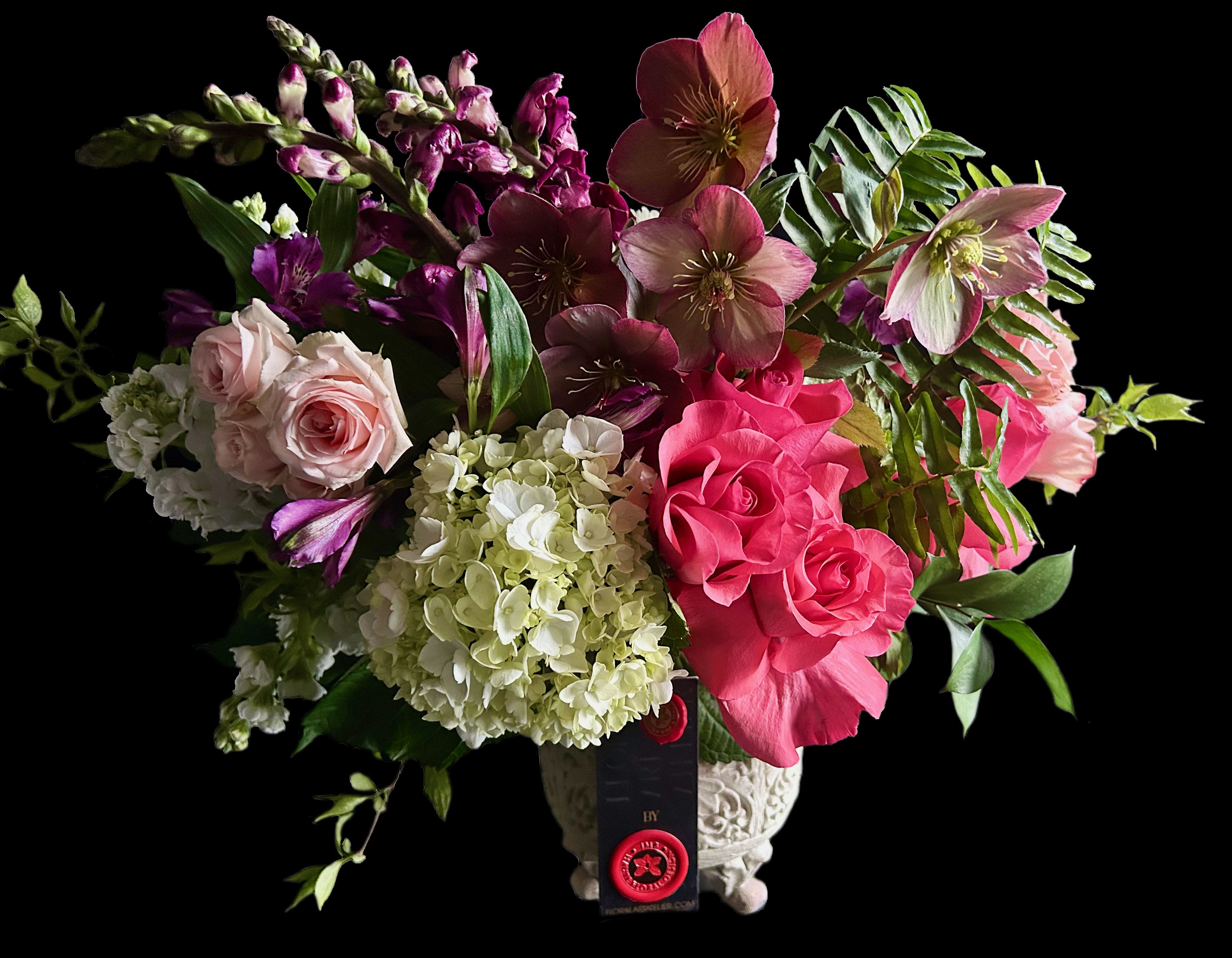 Mixed bouquet of pink roses, hydrangeas, and hellebores in a decorative vase