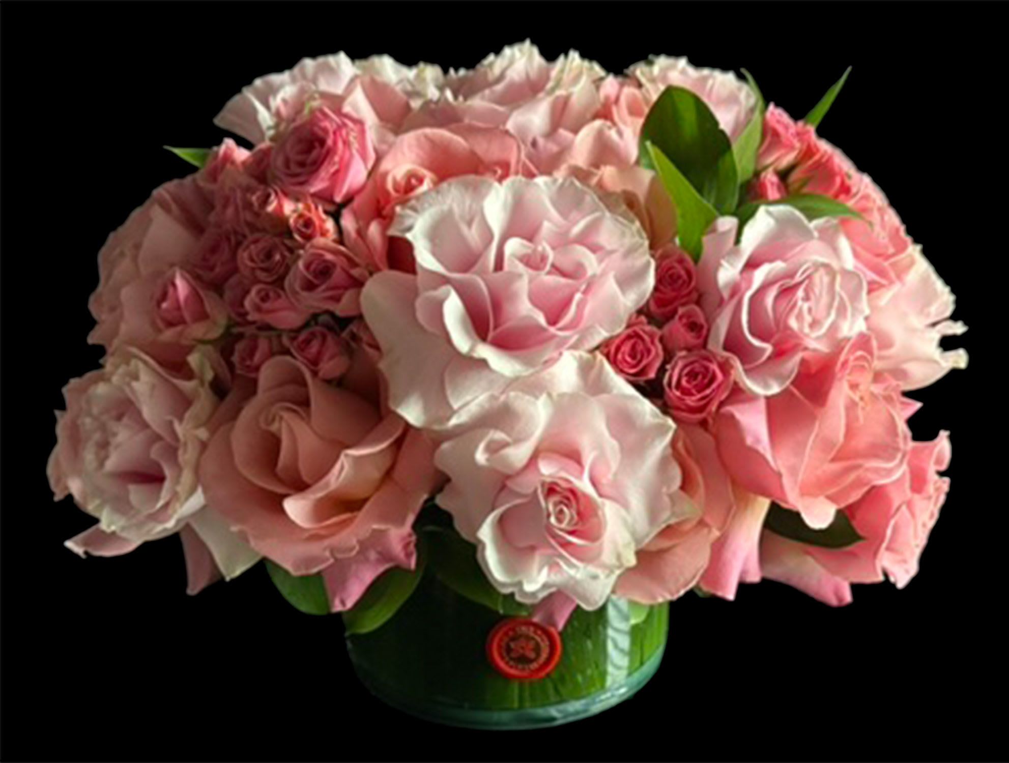 Lush Low Pink Arrangement - Lush Low Floral Arrangement in leaf lined glass vase in a combination of pink toned  reflexed and spray roses and foliage. 45+ stem count 