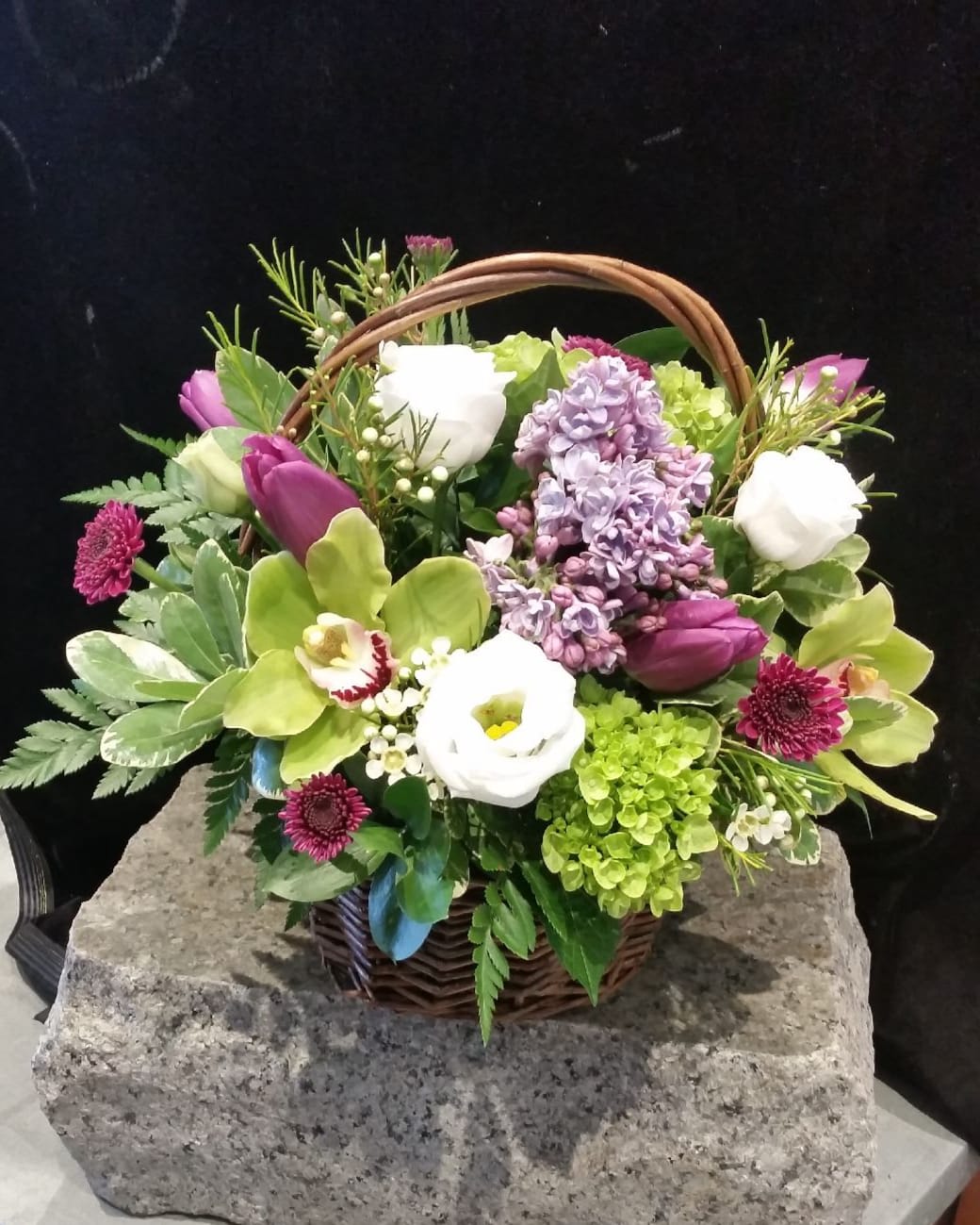 Mixed flower basket with purple, white, and green blooms