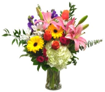 Mixed bouquet with lilies, gerbera daisies, roses, and hydrangea in a glass vase