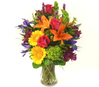 Mixed bouquet of roses, lilies, and daisies in a glass vase