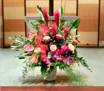 Large pink floral arrangement in a white pedestal vase
