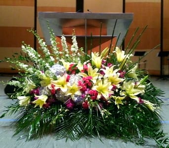 Large floral arrangement with yellow lilies and pink flowers