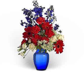 Red and white mixed bouquet in a blue vase with blue filler flowers