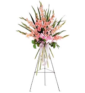 Tall pink standing spray with clustered blooms and ribbon bow on a metal easel.