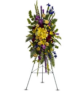 Tall standing spray of yellow lilies and mixed purple and blue flowers on a metal easel