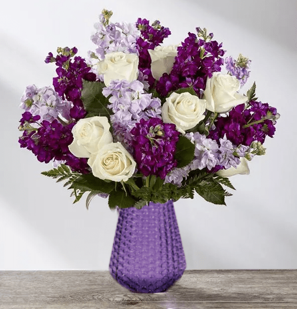 Purple and white roses in a textured purple vase