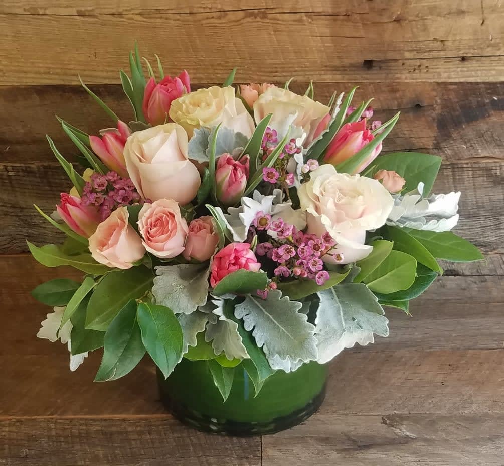 Pink and cream roses with tulips in a green vase
