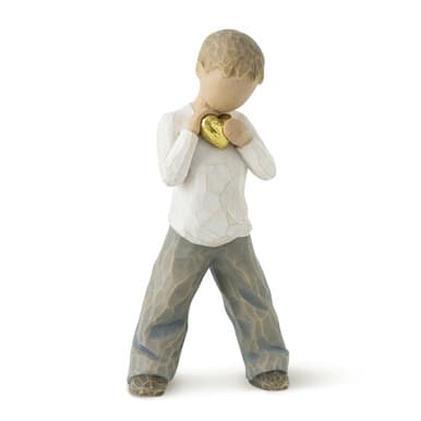 Small figurine holding a gold heart against its chest