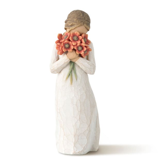 Figurine of a girl holding an orange flower bouquet