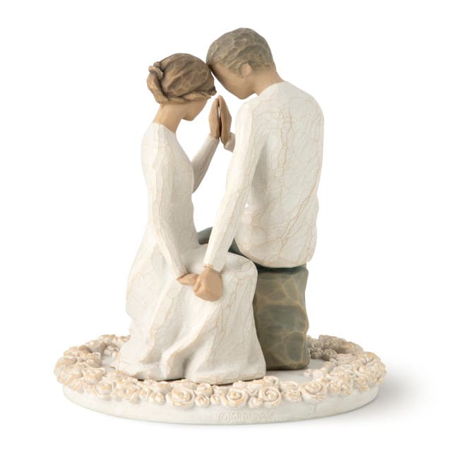 Figurine of a seated couple holding hands on a floral base