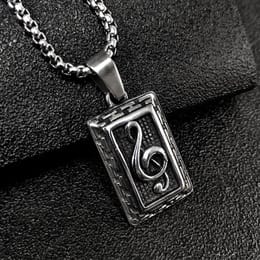 Silver music note pendant necklace on black fabric