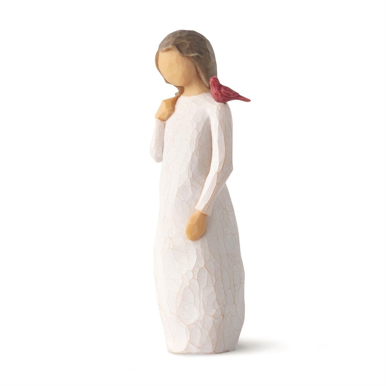 Small angel figurine in a white dress with a red bird on her shoulder