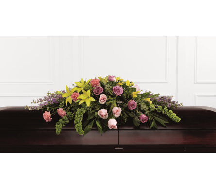 Casket spray with pink and purple roses and yellow lilies