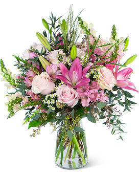 Tall pink and white bouquet with lilies and roses in a clear glass vase