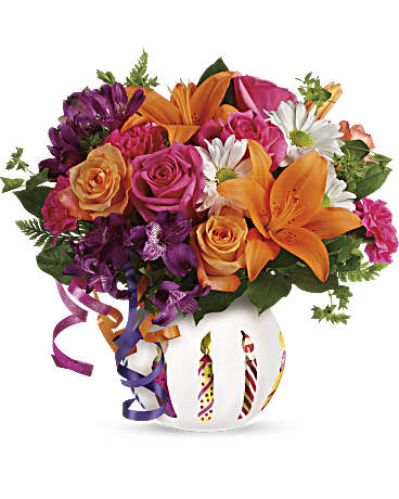 Colorful bouquet of roses, lilies, and daisies in a white vase